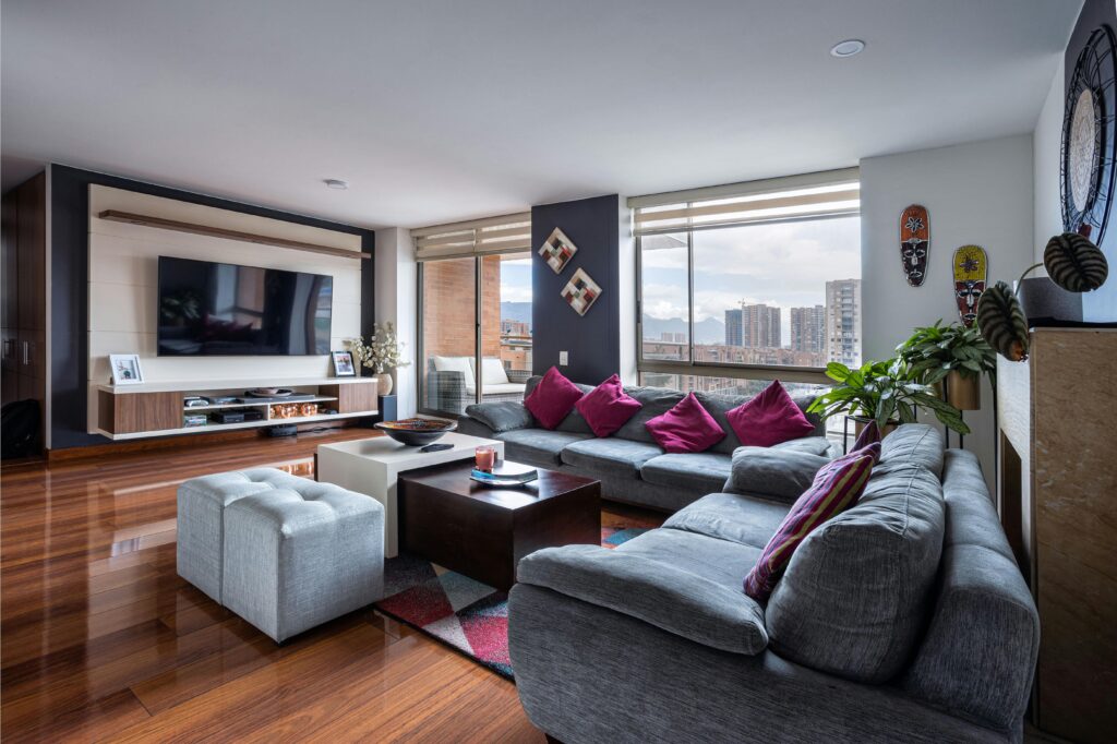 Spacious living room with modern decor, city view, and comfortable seating.