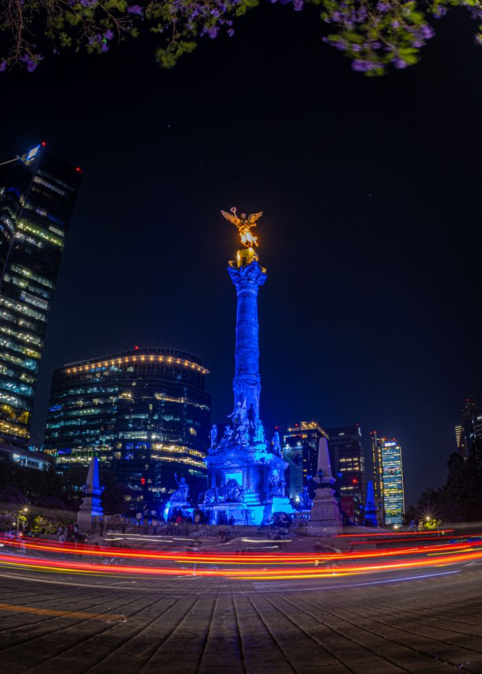 Stunning night shot of the Angel of Independence in Mexico City illuminated by city lights.